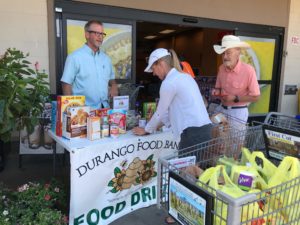 Holly Hagan, center, donates food to the Durango Food Bank on Thursday afternoon at south City Market. The food bank is accepting donations for people who have been displaced by the 416 Fire. On the left is Rick Crawford, the food bank’s development coordinator, and on the right is John Montle, a volunteer at the food bank.